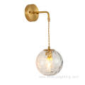 Copper wall lamp with suspended grain glass ball